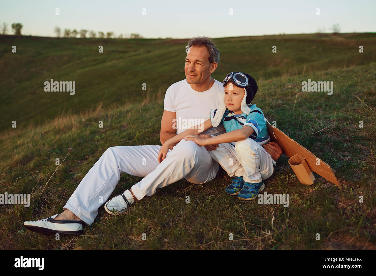 Father and son i sitting on the grass at sunset in nature Stock Photo ...