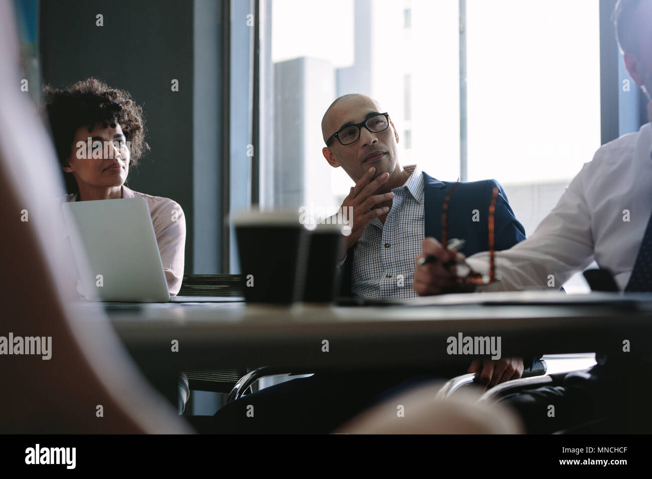 Businessman listening and paying attention to the discussion during a strategy meeting. Corporate professionals having a strategy discussion in office Stock Photo
