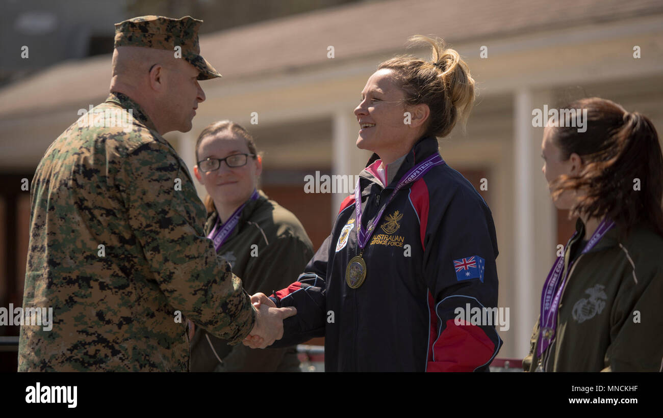 Australian athlete Maj. Kelliegh Jackson shakes hands with U.S. Marine Corps Sgt. Maj. Karl Simburger during the 2018 Marine Corps Trials cycling competition medal ceremony at Marine Corps Base Camp Lejeune, N.C., March 18, 2018. The Marine Corps Trials promotes recovery and rehabilitation through adaptive sport participation and develops camaraderie among recovering service members (RSMs) and veterans. It is an opportunity for RSMs to demonstrate their achievements and serves as the primary venue to select Marine Corps participants for the DoD Warrior Games. (U.S. Marine Corps Stock Photo