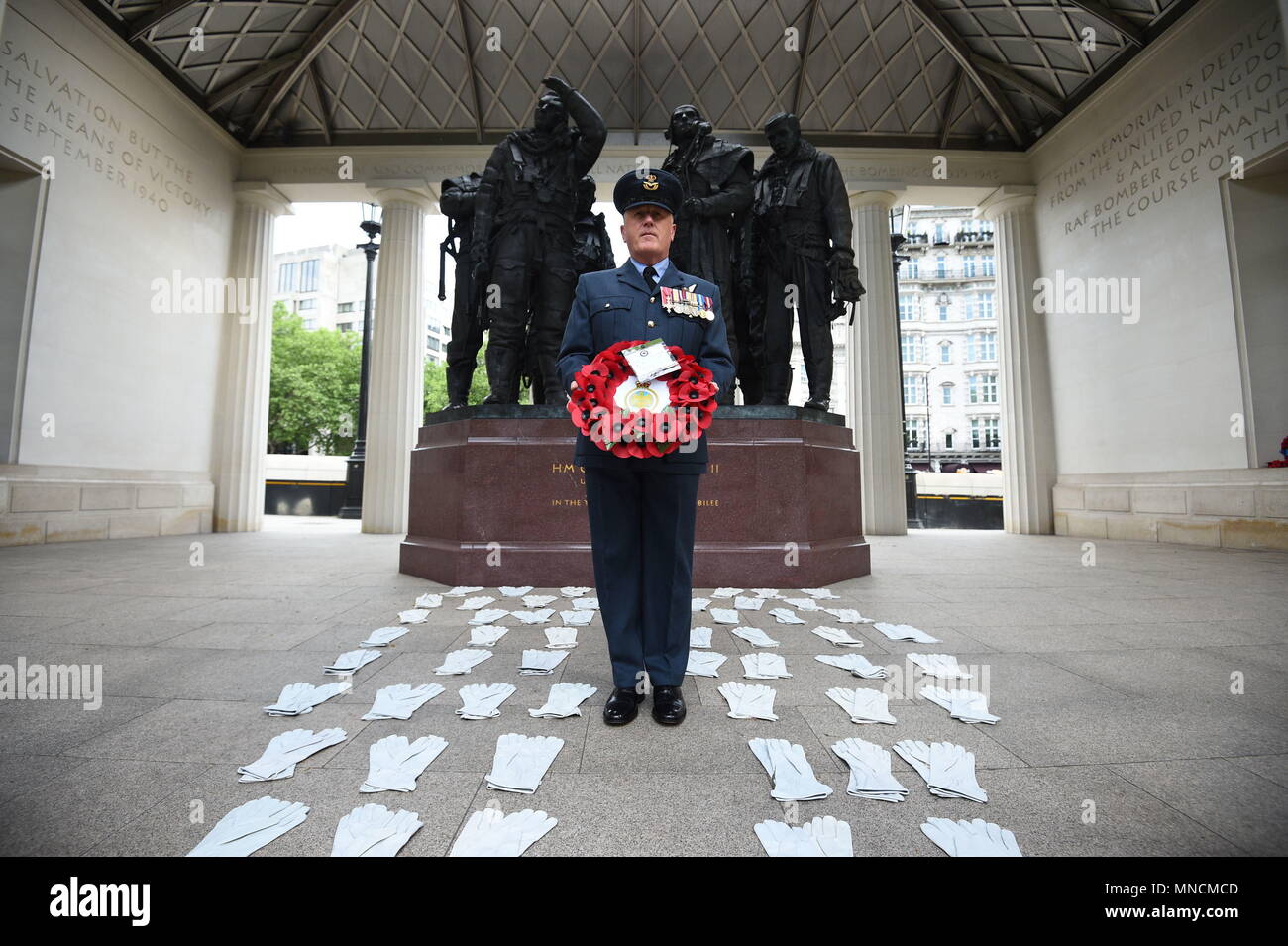 Flight Lieutenant Nigel Painter holds a wreath as he stands among 53 pairs of flying gloves at the Bomber Command Memorial in London's Green Park which represent the men who died in the Dambusters raids in 1943, part of a series of special events marking 75 years since a brave band of airmen took part in one of the most daring raids of the Second World War. Stock Photo