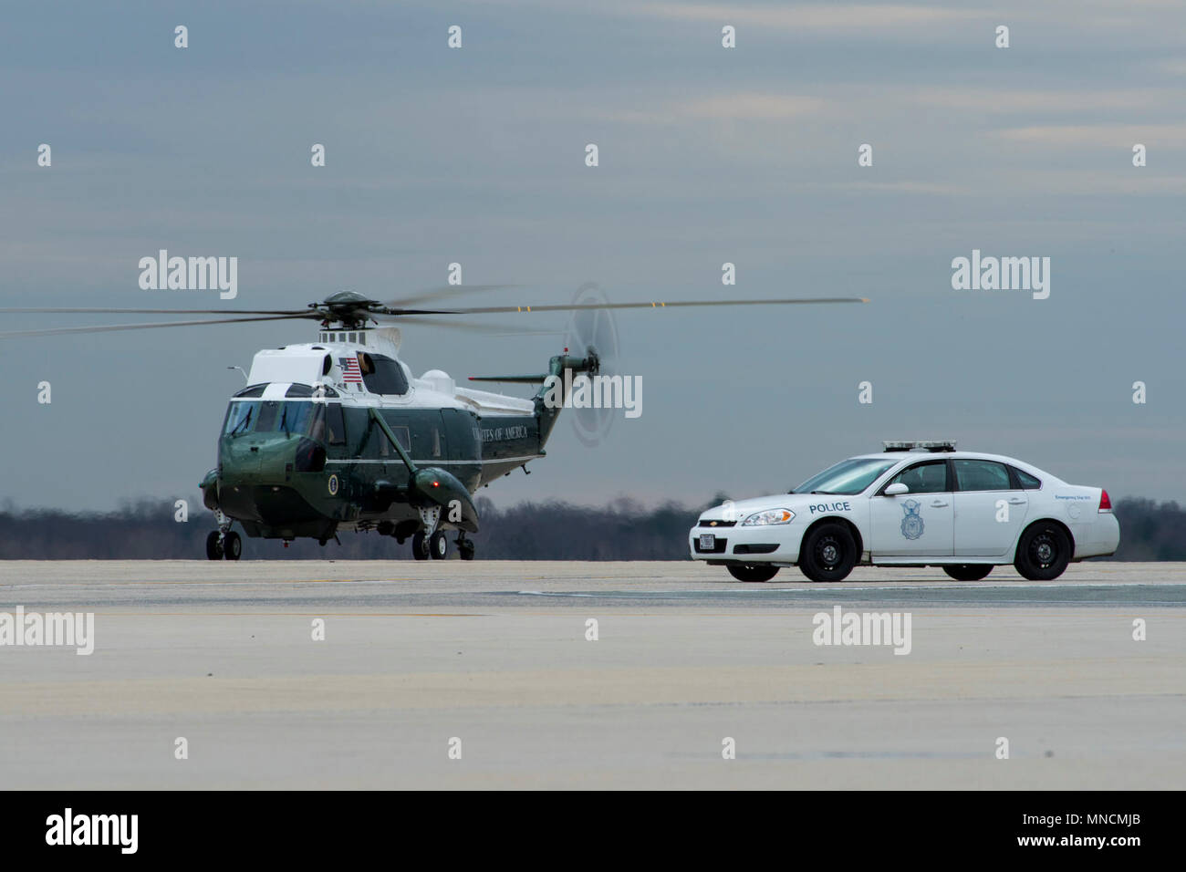 A Sikorsky VH-3D Sea King operated by Marine Helicopter Squadron One, sits on the runway near a security forces vehicle at Joint Base Andrews, Md., March 19, 2018. Stock Photo