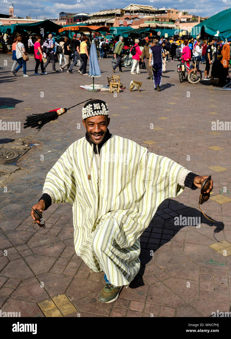 Percussionist in traditional costume entertaining tourists in the Jemaa El Fna, a world heritage site, Marrakech, Morocco Stock Photo