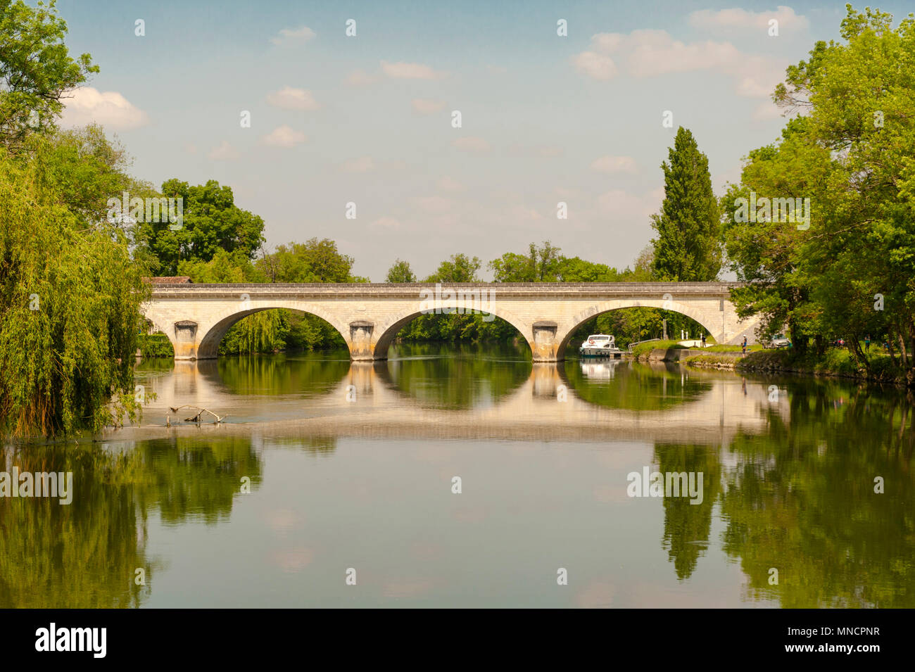 The bridge of Juac reflected by the waters of the Charente river, south-west France Stock Photo