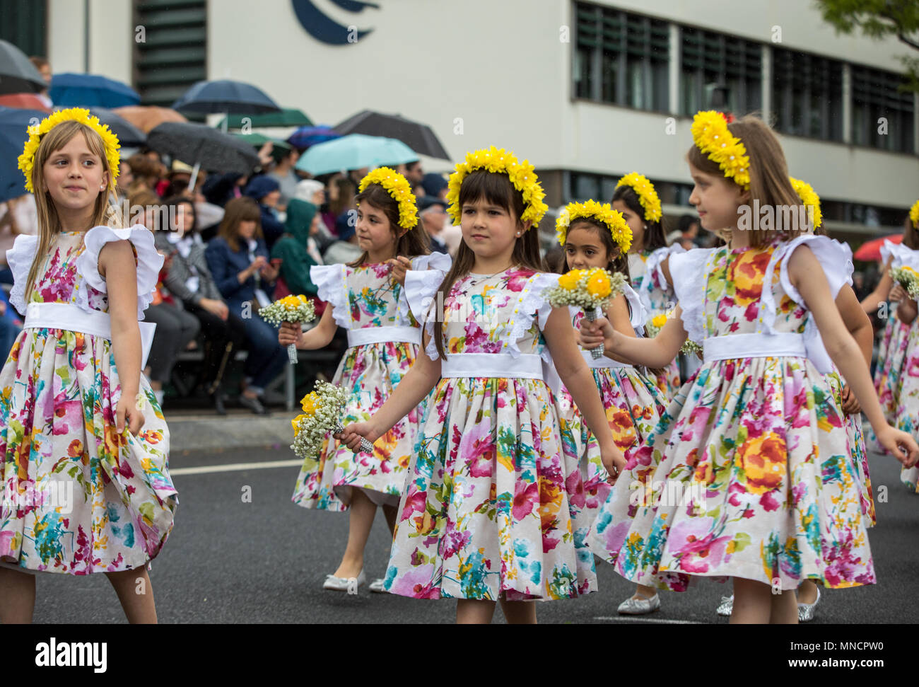 Funchal; Madeira; Portugal - April 22; 2018: A group of girls in colorful dresses are dancing at Madeira Flower Festival Parade in Funchal on the Isla Stock Photo