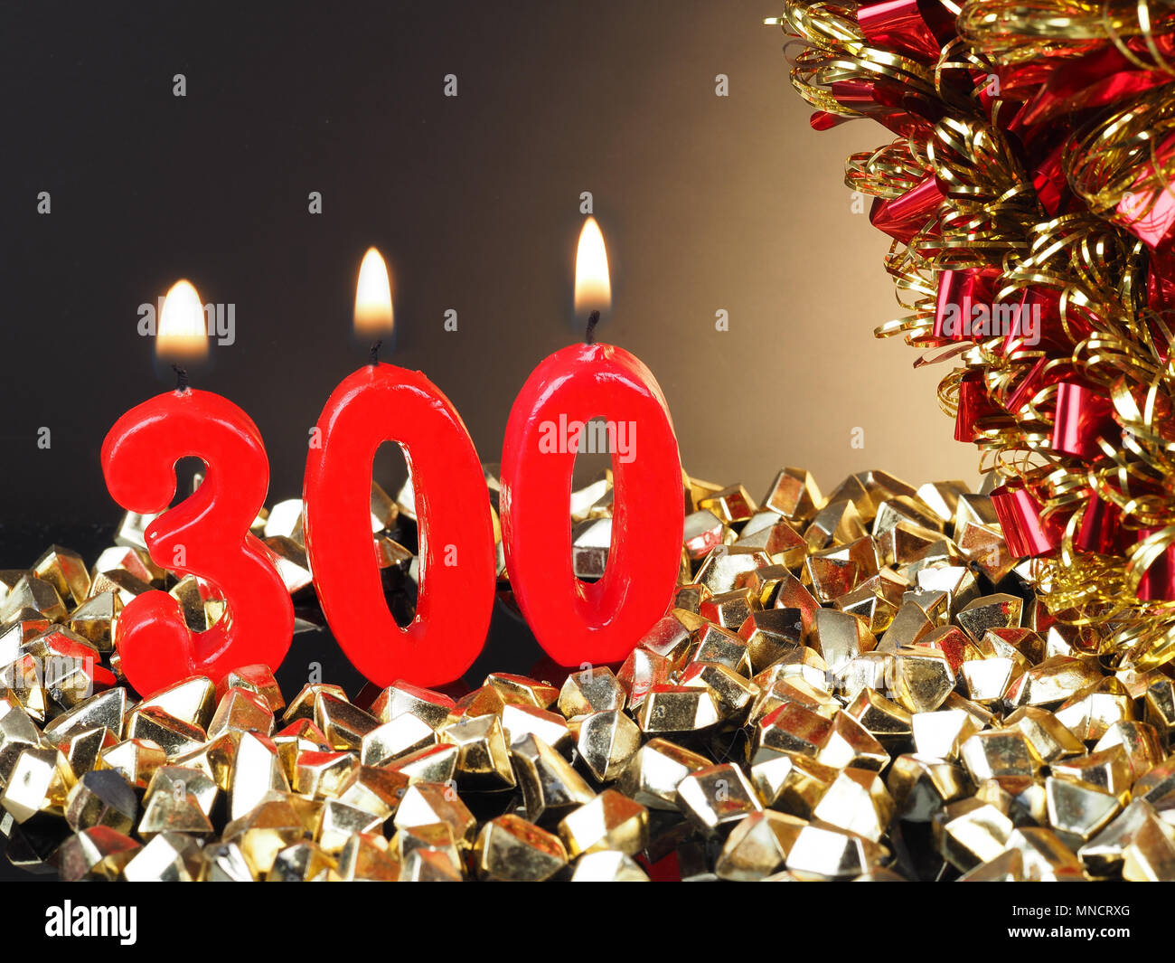 Birthday-anniversary candle showing Nr. 300 Lit red candle good for an  anniversary or birthday background Stock Photo - Alamy