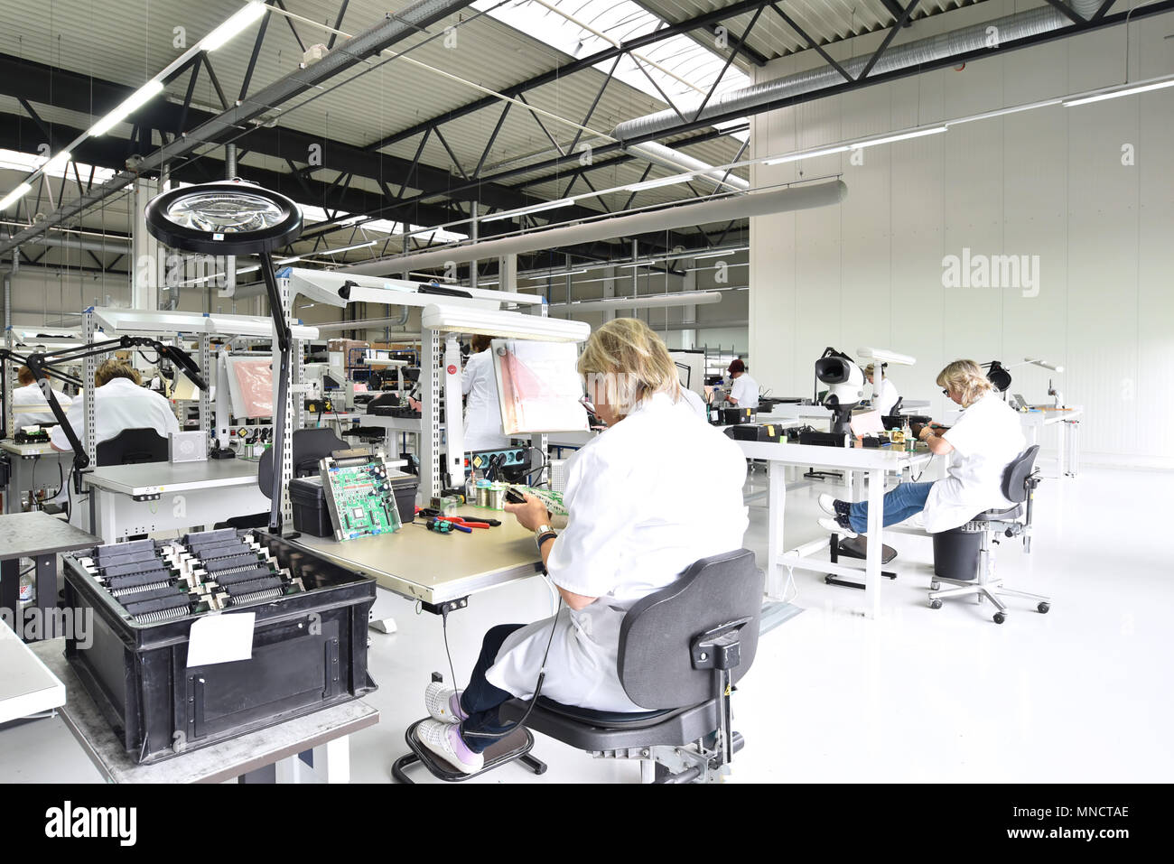 industrial factory for assembly of microelectronics - interior and group of female workers Stock Photo