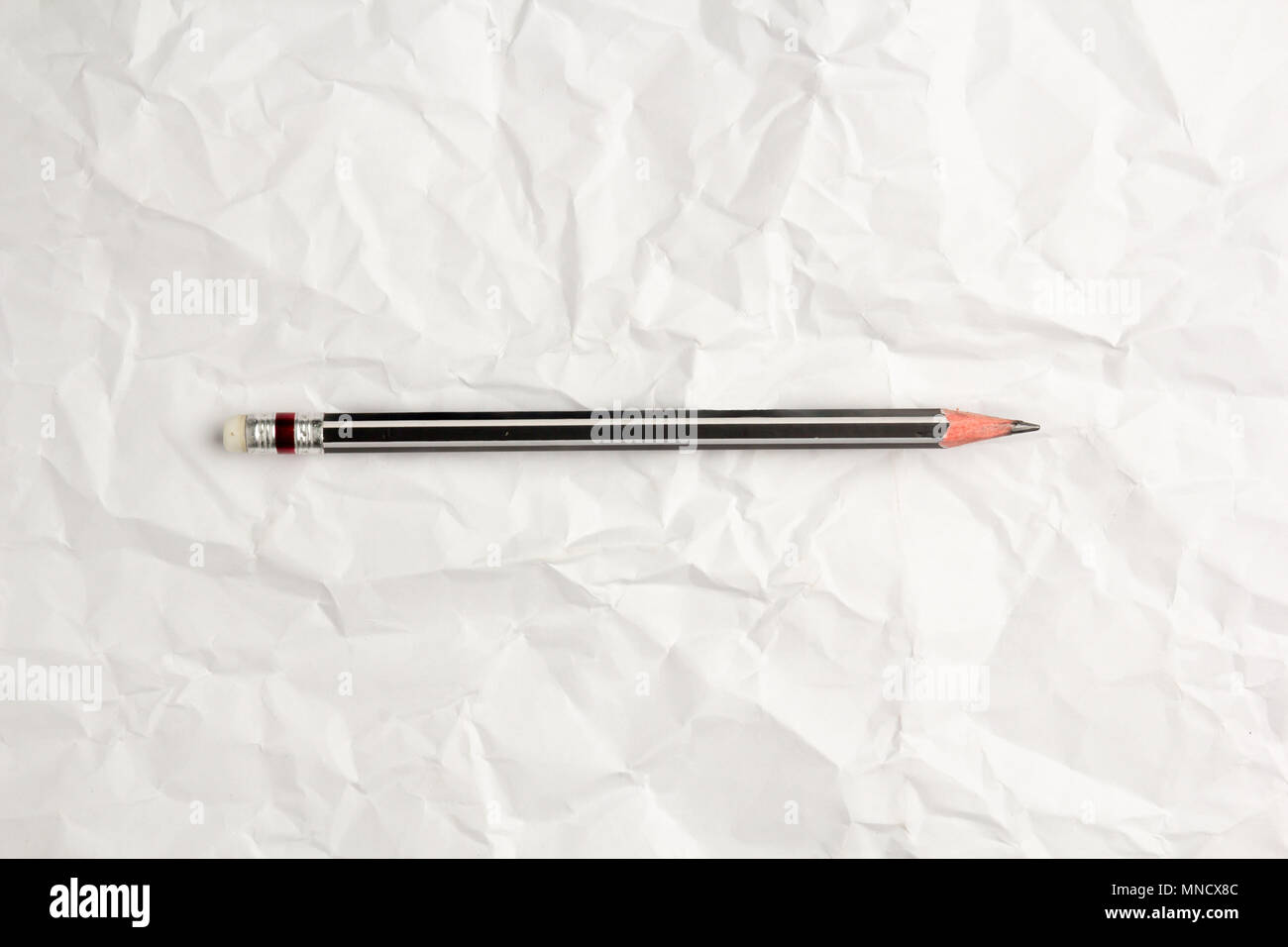 Put a pencil on crumpled paper background Stock Photo