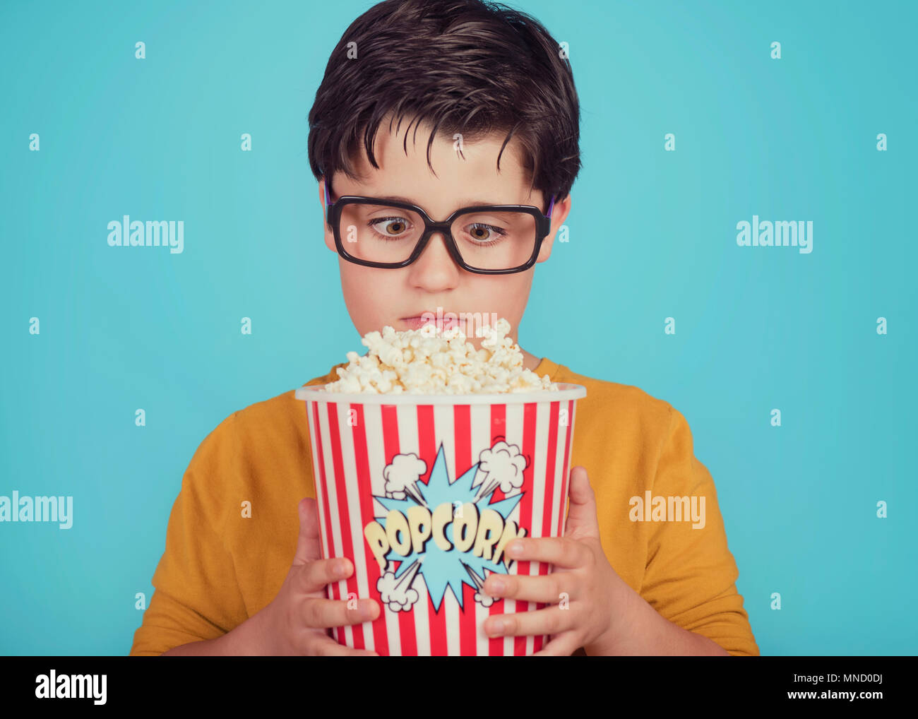 little boy child with popcorn on blue background Stock Photo