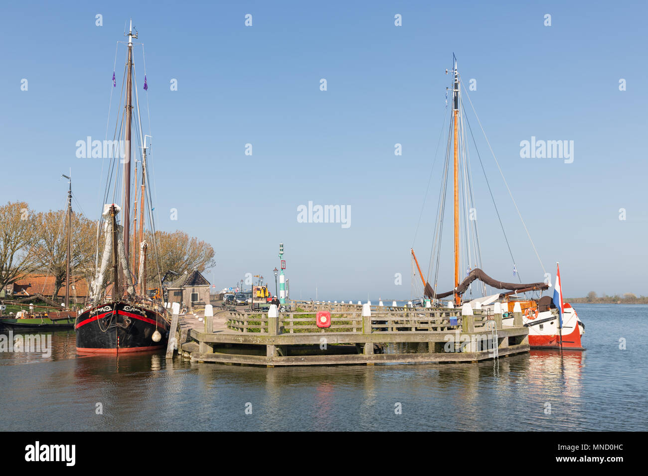Enkhuizen, The Netherlands - April 20, 2018: Traditional barge in harbor of Enkhuizen with people relaxing in the sun Stock Photo