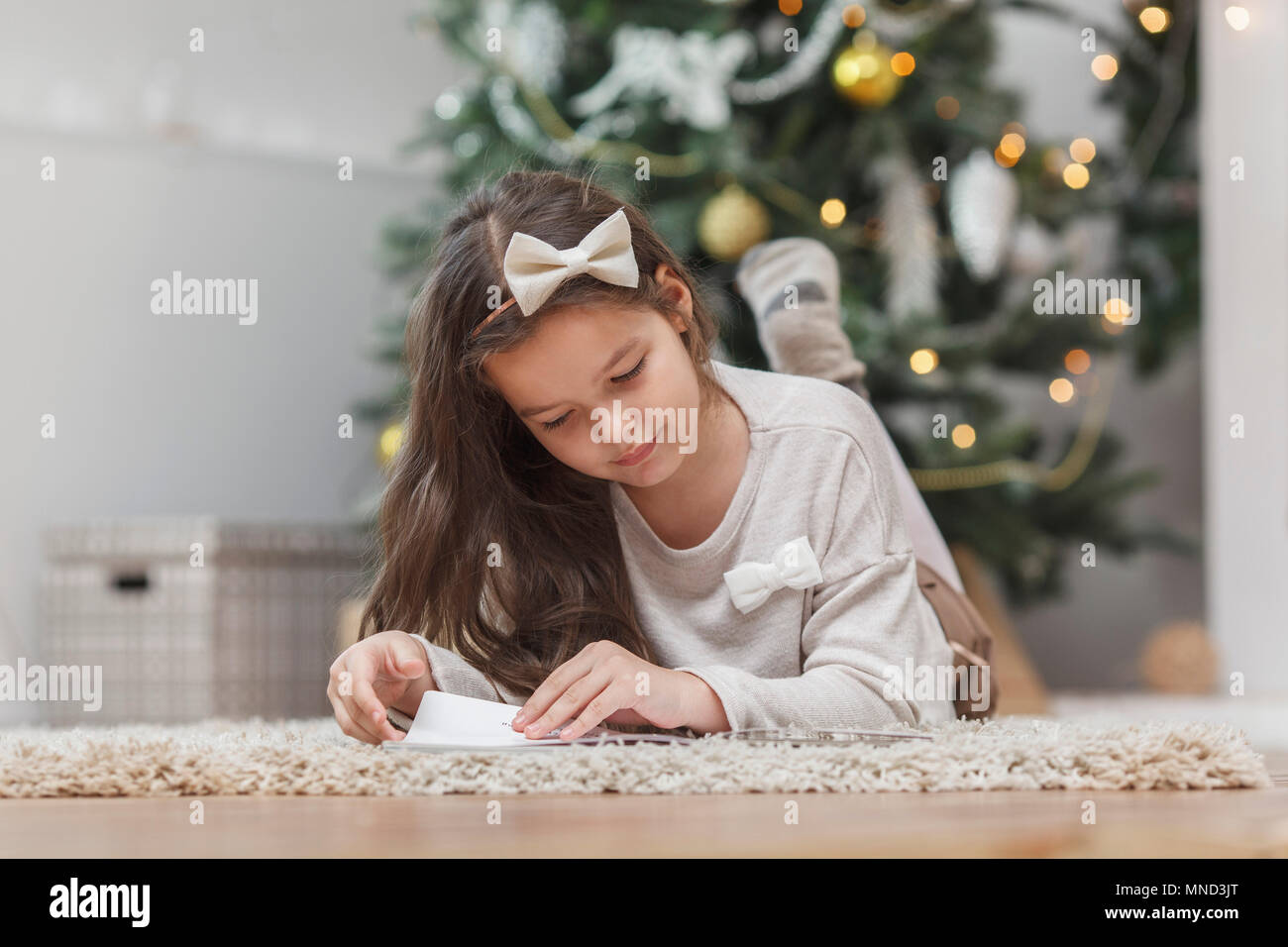 Girl lying on rug while reading book at home Stock Photo