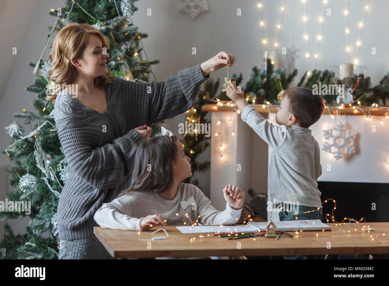 Playful woman with children at home during Christmas Stock Photo