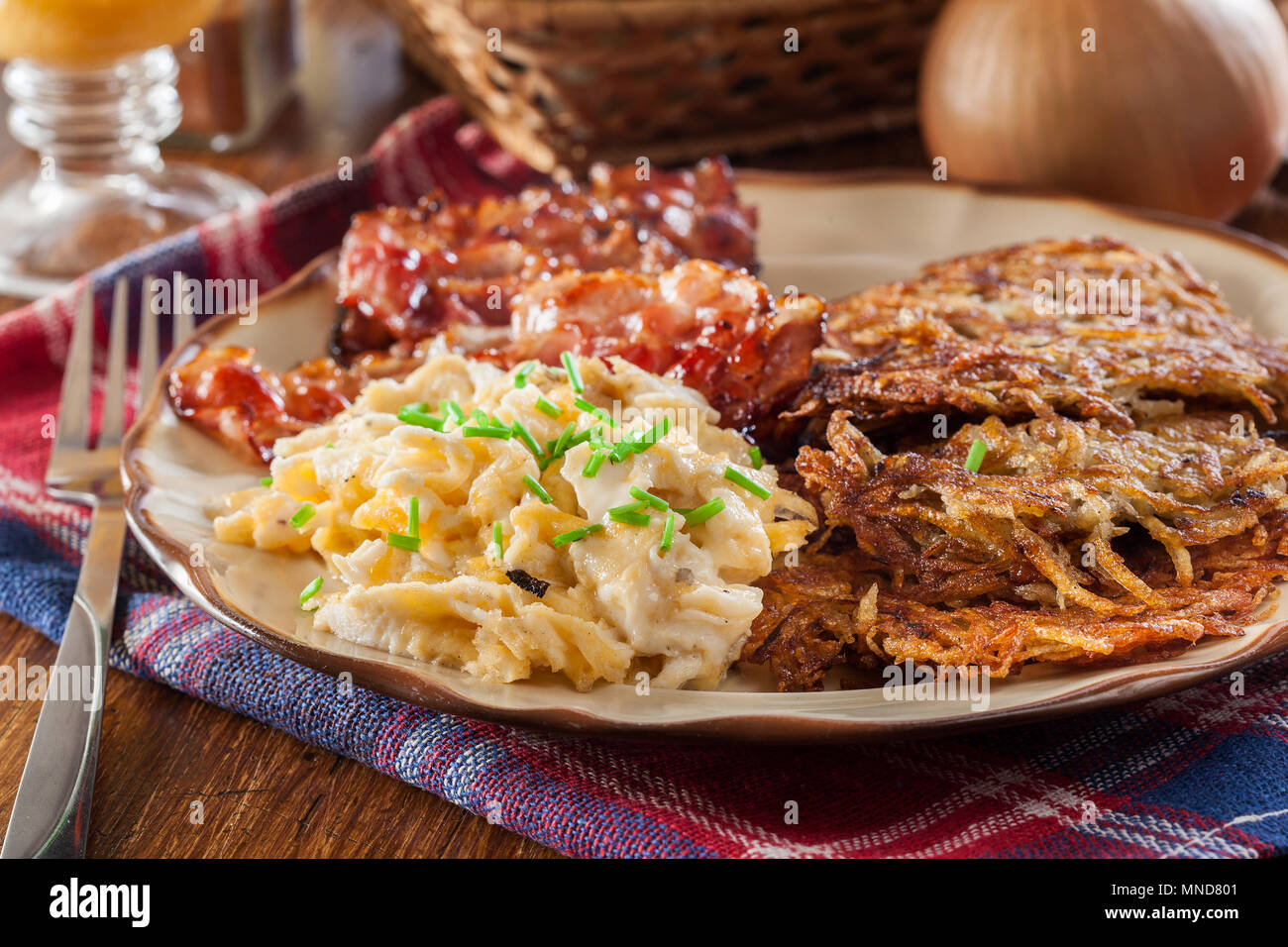 Hash browns. Potato pancakes with crispy fried bacon and scrambled eggs