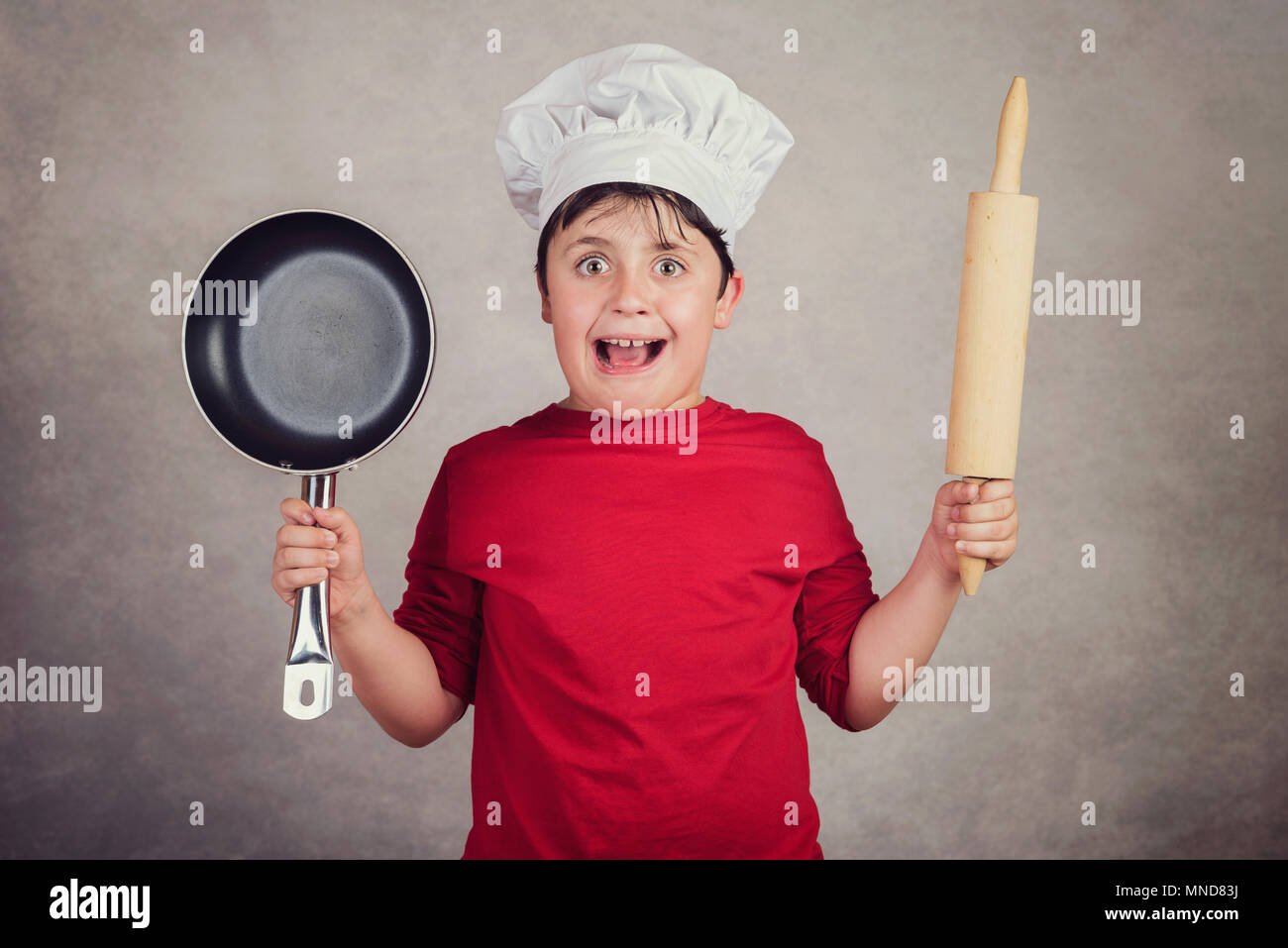 angry cook child on gray background Stock Photo