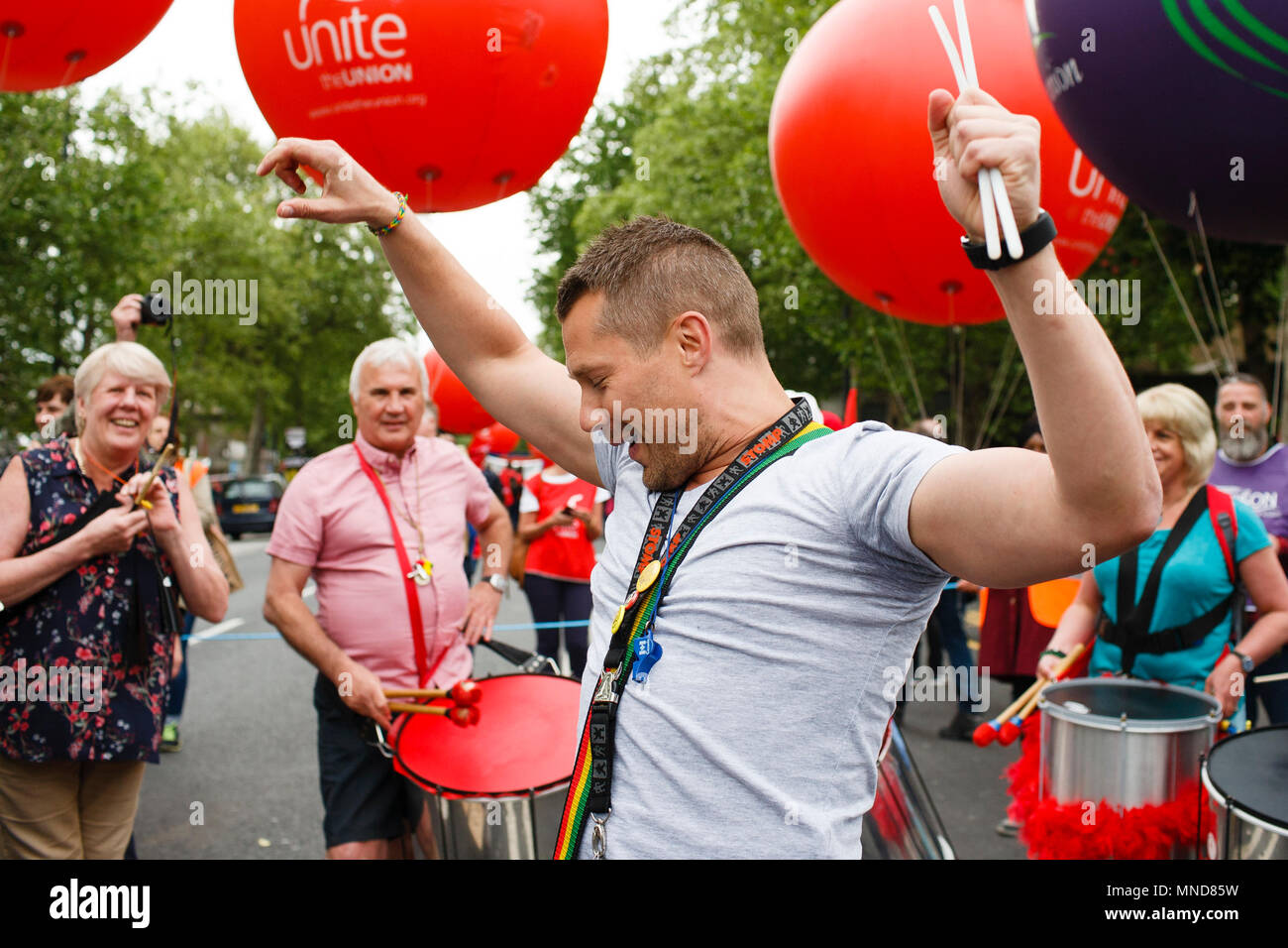 A drummer dances amidst his bandmates as demonstrators calling for fairer pay and rights for workers, as well as against public service cuts and workplace discrimination, gather on Victoria Embankment ahead of the 'New Deal for Working People' march organised by the Trades Union Congress (TUC). Stock Photo