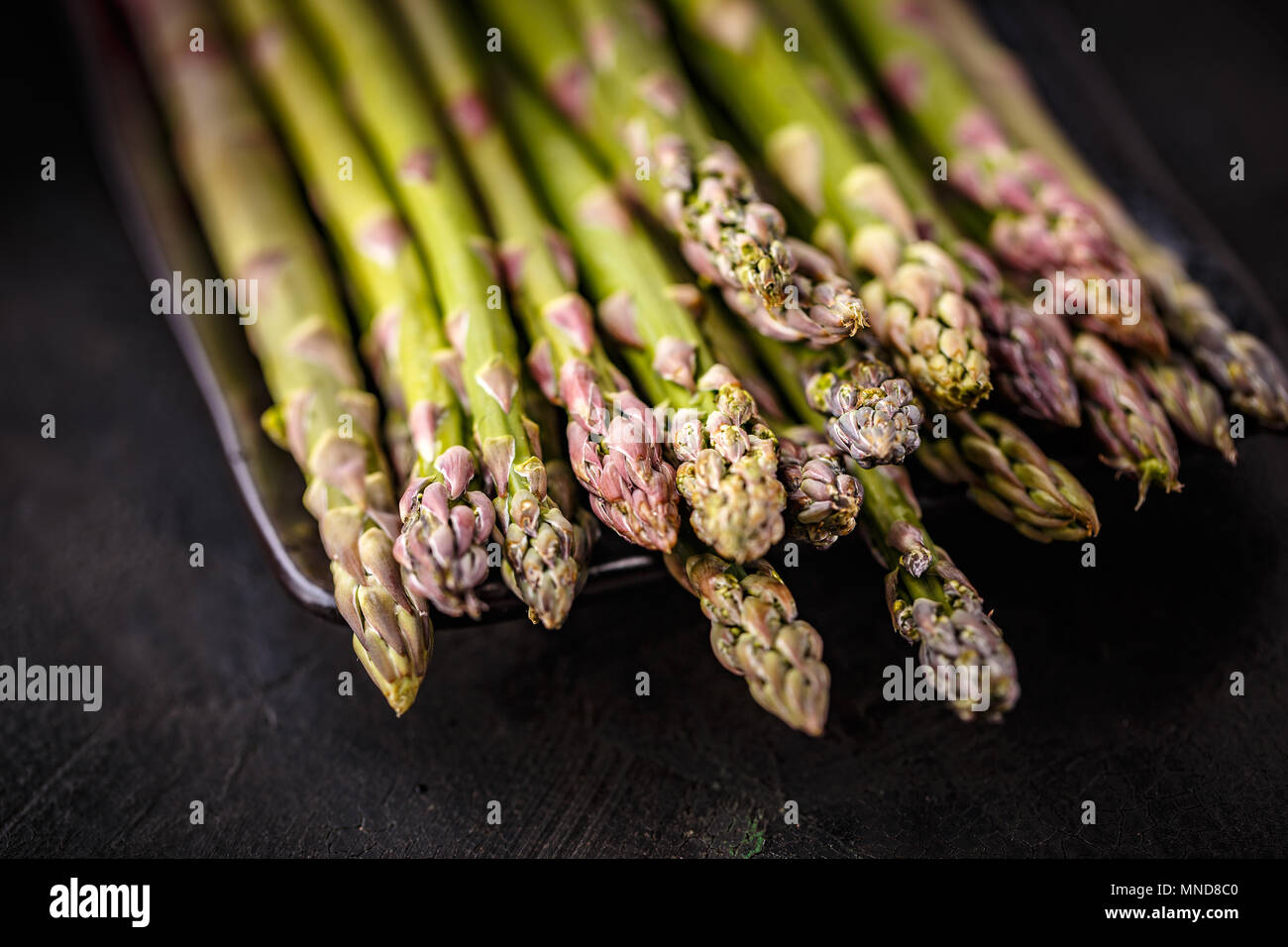 Bunch of fresh asparagus on black background, close up Stock Photo