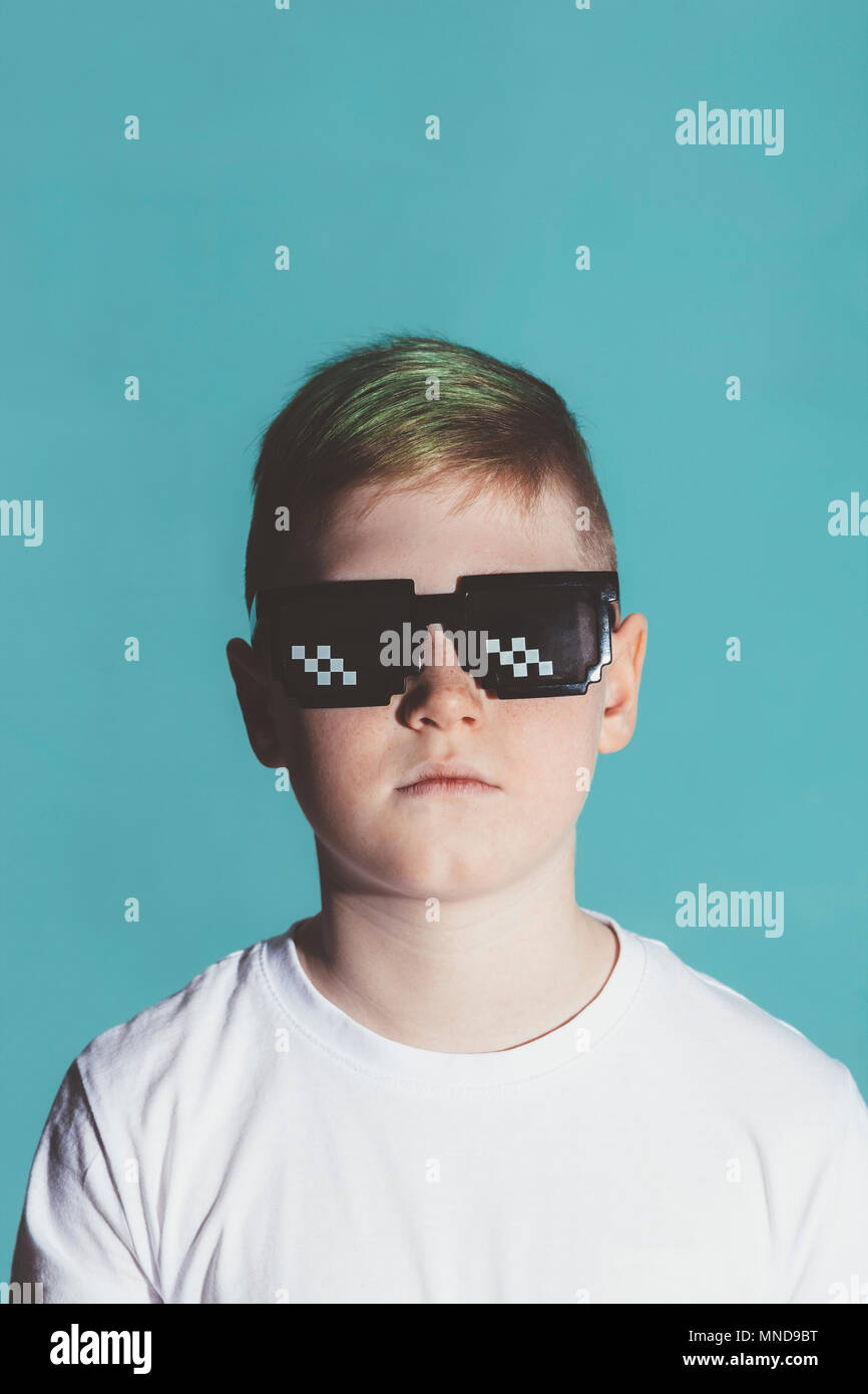 Boy wearing sunglasses against blue background Stock Photo