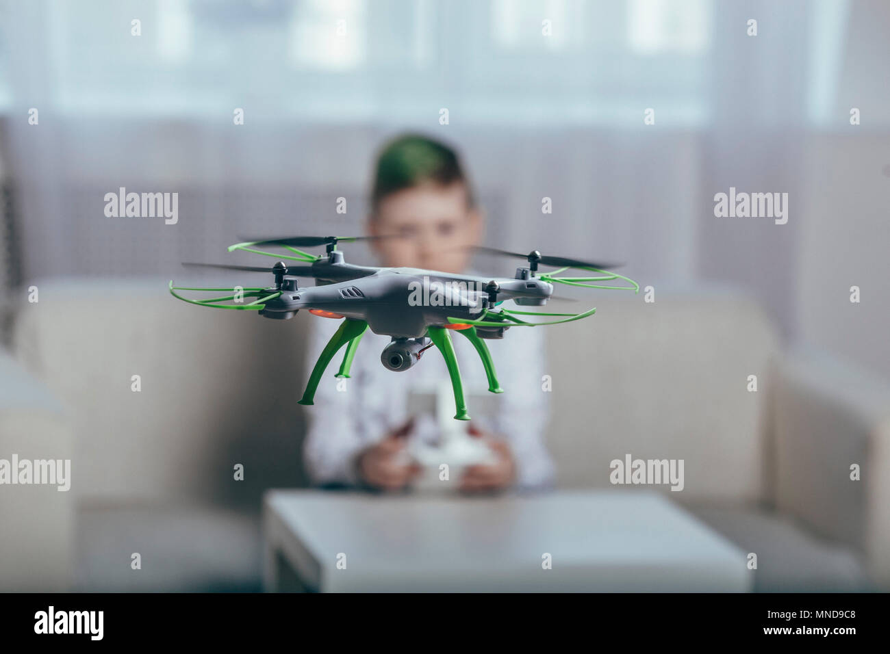 Boy flying drone in living room at home Stock Photo