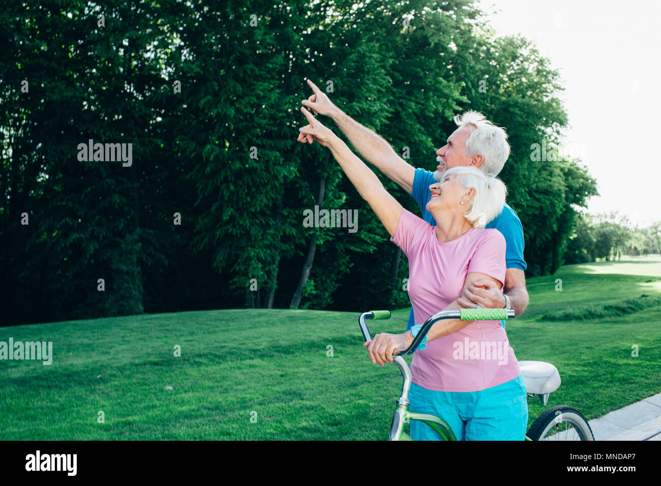 caucasian elderly couple pointing hand to side Stock Photo