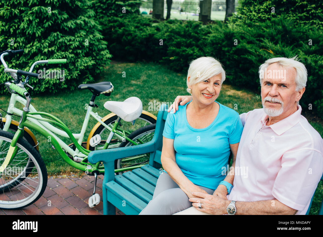 portrait of an elderly couple sitting in a city park Stock Photo