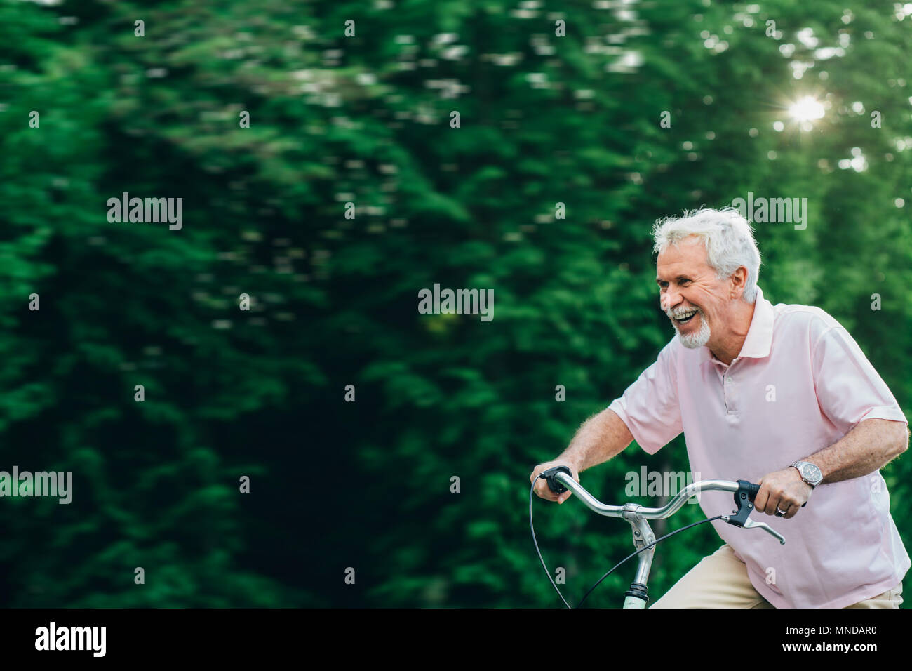 Happy senior man cycling. Stock Photo