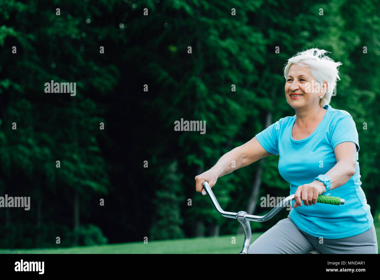 Happy senior woman cycling. Stock Photo