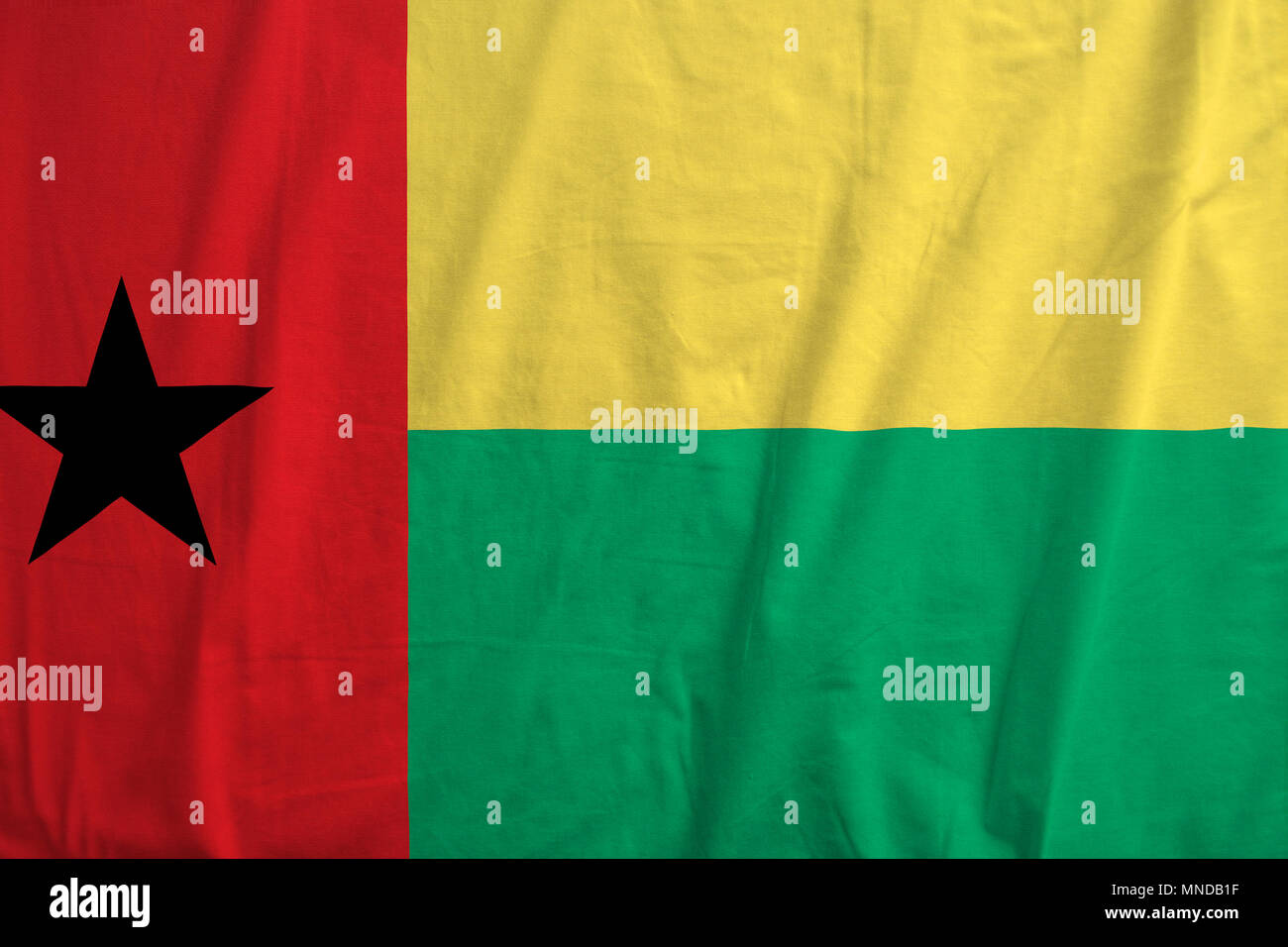 Fabric texture of the flag of Guinea Bissau. Stock Photo