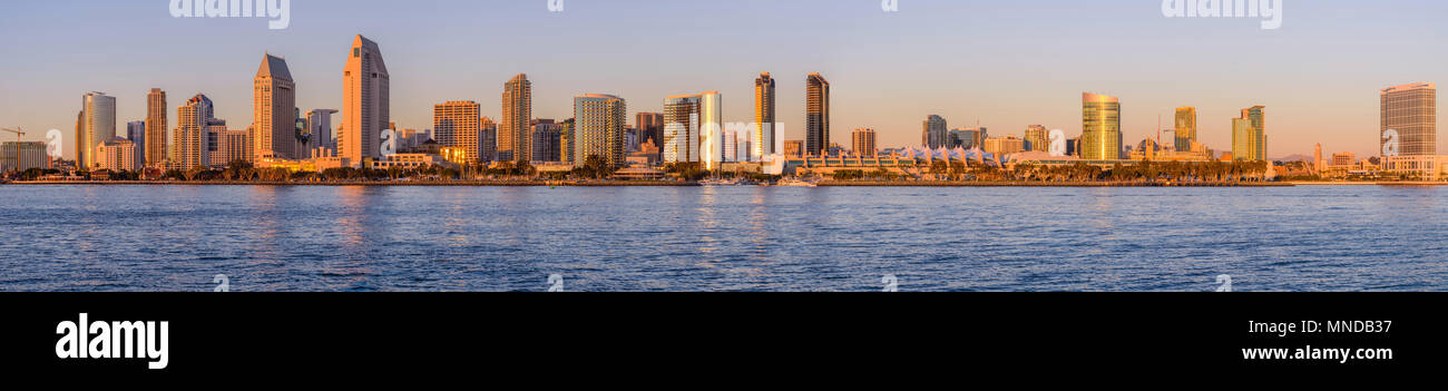 Sunset San Diego Skyline - A panoramic sunset view of waterfront skyline of San Diego Downtown at San Diego Bay, looking from Coronado Peninsula, CA. Stock Photo
