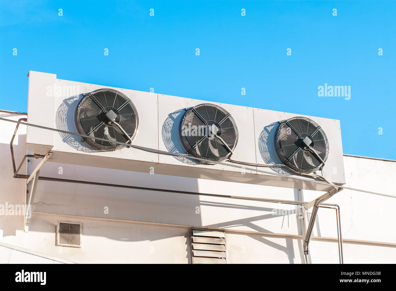 Air compressors installed on the wall of building with sunlight sky ...