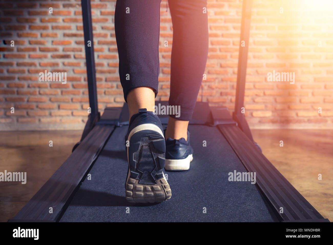 Close up on shoe athlete, Woman running in a gym on a treadmill . exercising and sunlight effect, fitness and healthy lifestyle Stock Photo