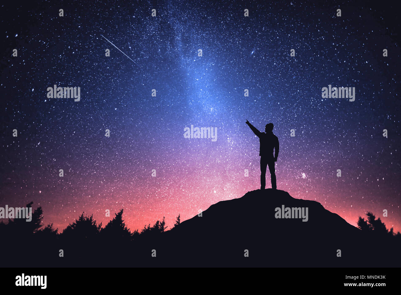 Night sky with stars and silhouette of a standing man Stock Photo