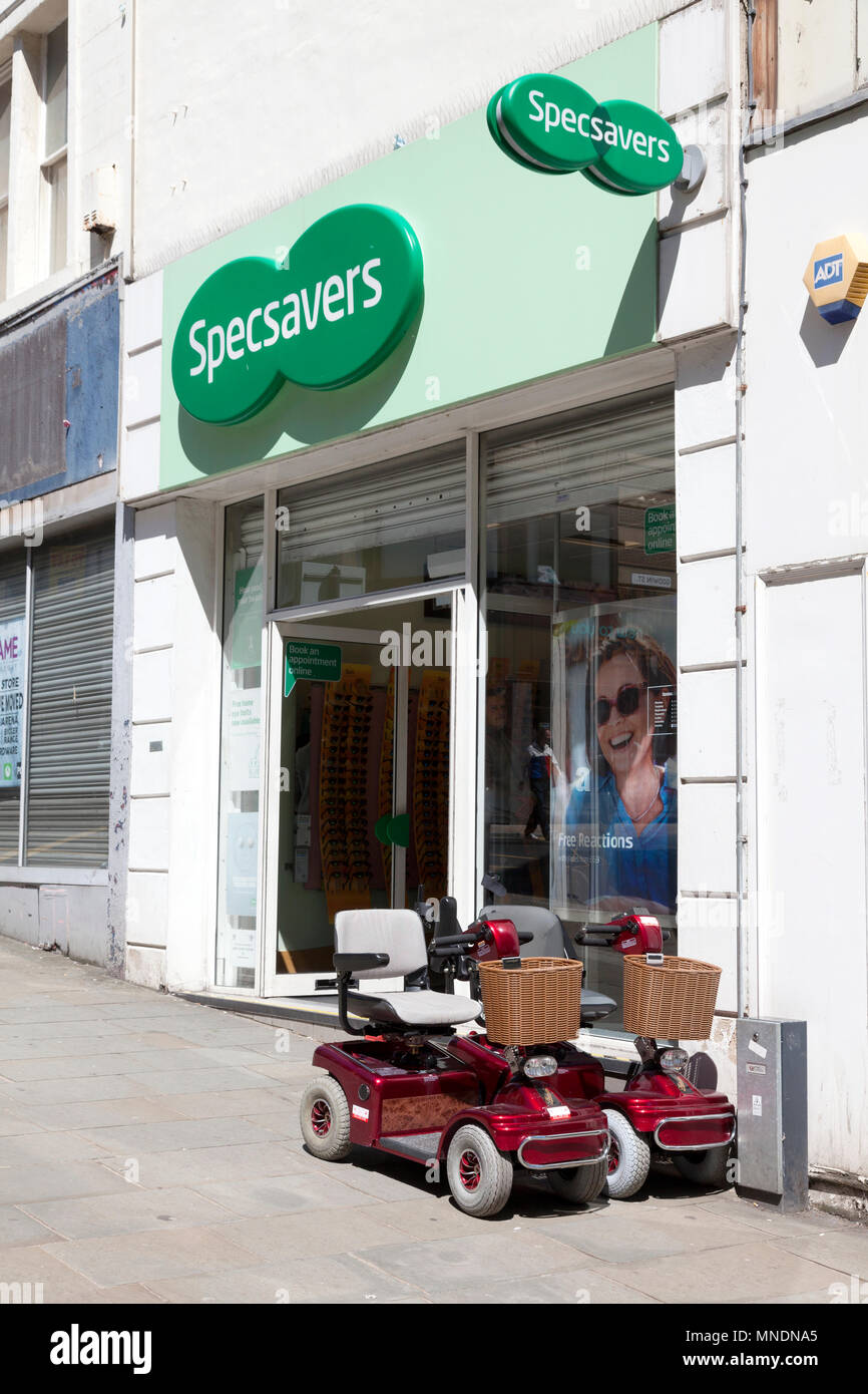 Mobility scooters parked outside Specsavers, Bradford, West Yorkshire Stock Photo