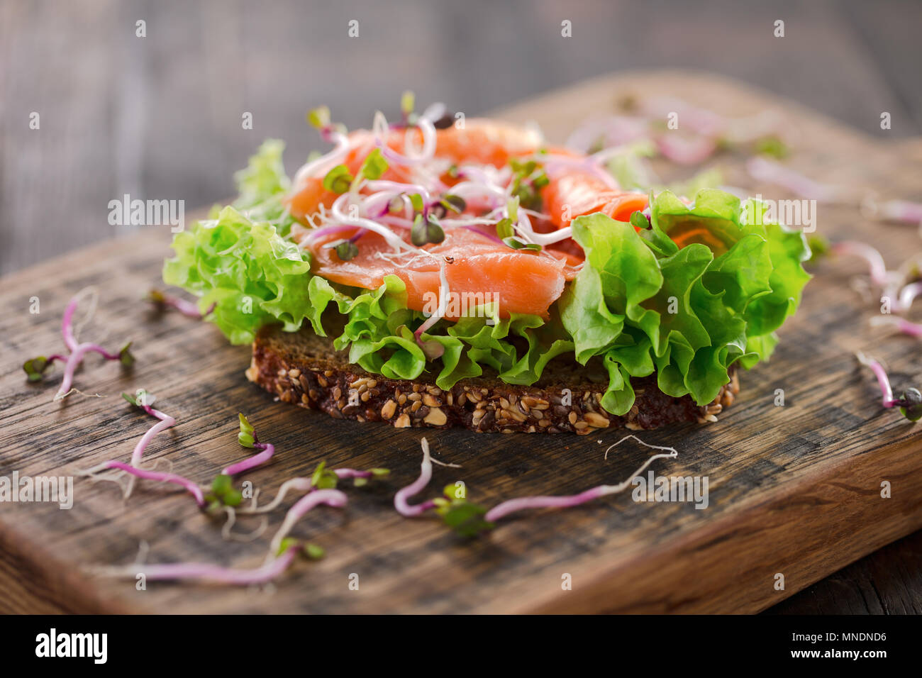 A healthy sandwich on a rustic kitchen board. Whole wheat bread with