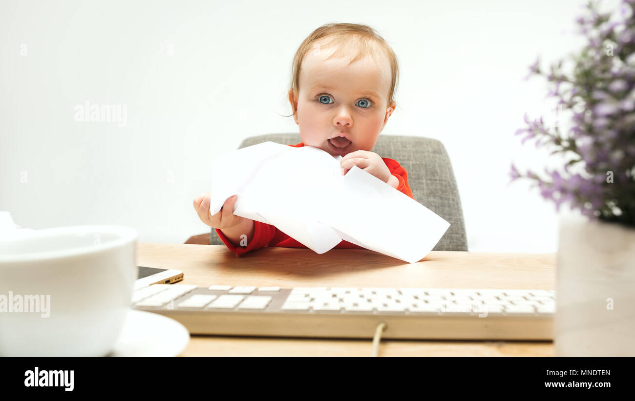 Happy child baby girl toddler sitting with keyboard of computer