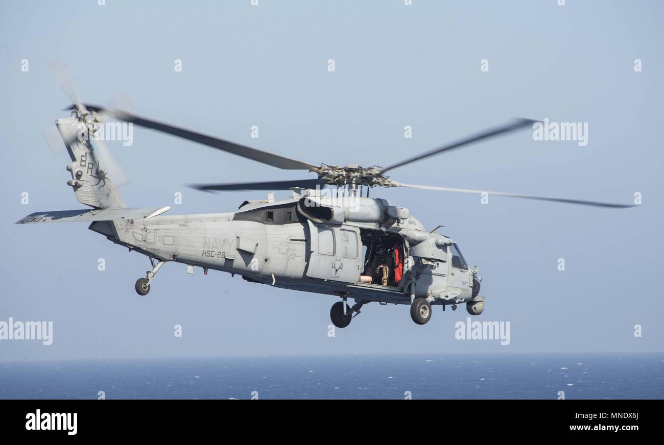 180515-N-AH771-0081 U.S. 5TH FLEET AREA OF OPERATIONS (May 15, 2018) An MH-60S Seahawk, attached to Helicopter Sea Squadron (HSC) 28, takes off from the flight deck of the Wasp-class amphibious assault ship USS Iwo Jima (LHD 7) during a replenishment-at-sea, May 15, 2018, May 15, 2018. Iwo Jima, homeported in Mayport, Fla. is on deployment to the U.S. 5th Fleet area of operations in support of maritime security operations to reassure allies and partners, and preserve the freedom of navigation and the free flow of commerce in the region. (U.S. Navy photo by Mass Communication Specialist 3rd Cla Stock Photo