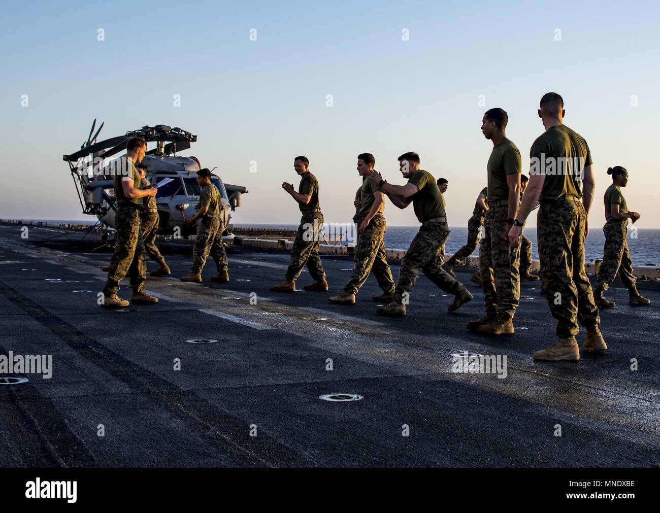 180515-N-ZK016-0002 U.S. 5TH FLEET AREA OF OPERATIONS (May 15, 2018) Marines, assigned to the 26th Marine Expeditionary Unit practice hand-to-hand combat exercises on the flight deck of the Wasp-class amphibious assault ship USS Iwo Jima (LHD 7), May 15, 2018, May 15, 2018. Iwo Jima, homeported in Mayport, Fla. is on deployment to the U.S. 5th Fleet area of operations in support of maritime security operations to reassure allies and partners, and preserve the freedom of navigation and the free flow of commerce in the region. (U.S. Navy photo by Mass Communication Specialist 3rd Class Joe J. Ca Stock Photo