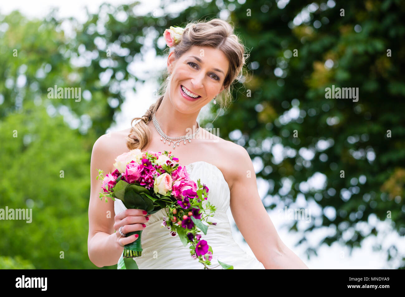 Bride in wedding dress with bridal bouquet Stock Photo - Alamy