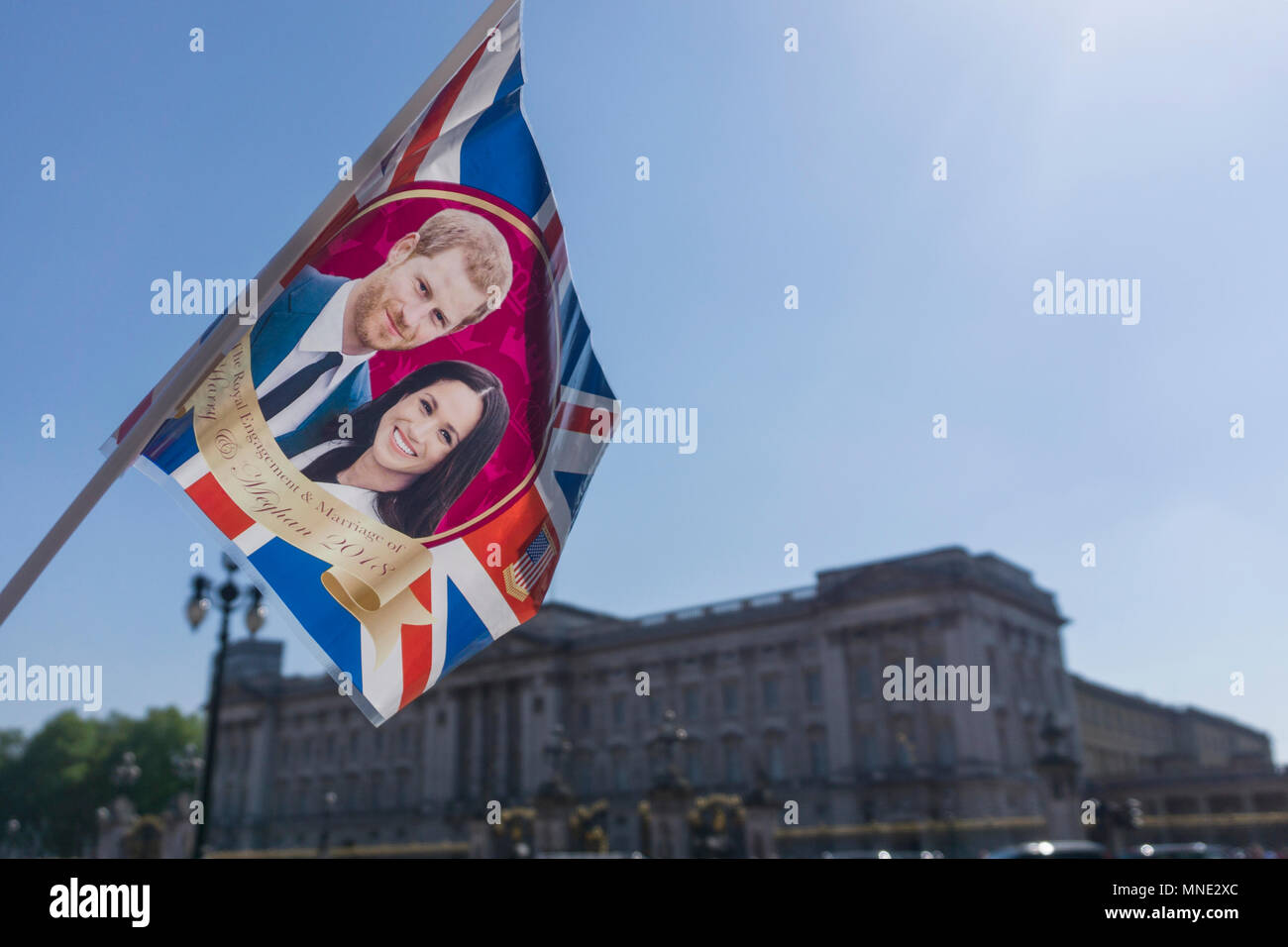 London, UK. 15th May 2018. Union jack flag with Prince Harry and Meghan Markle on is waved outside Buckingham palace before the Royal Wedding takes place in Windsor Credit: Ink Drop/Alamy Live News Stock Photo