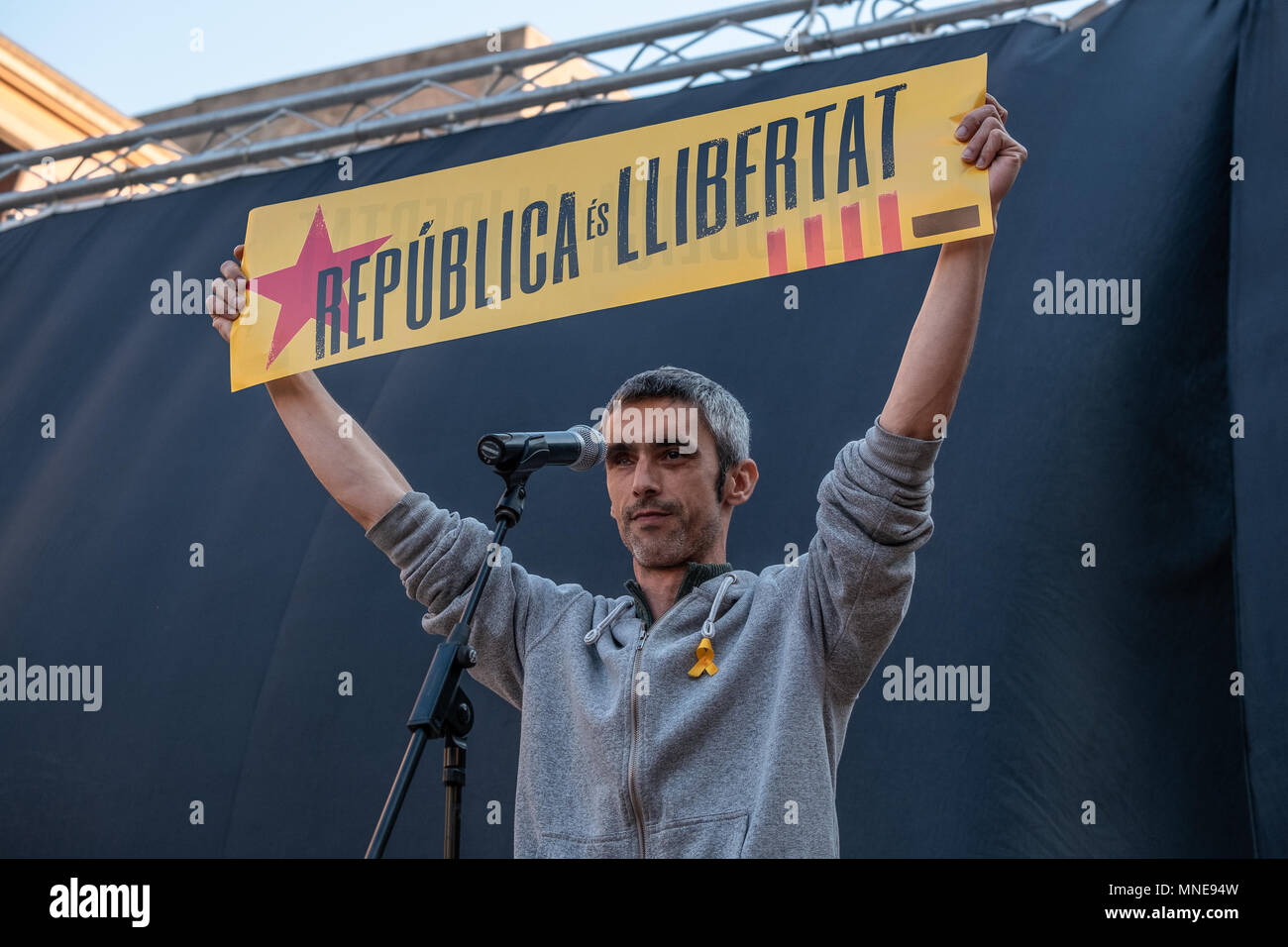 Roger Español, the young man who lost an eye during the repression of the election day of October 1 is seen on the stage raising a sign with the text 'Catalan Republic'. Act of protest to request the release of political prisoners Jordi Sànchez and Jordi Cuixart who have been in prison for seven months. It is the circumstance that it has been the first act in Catalonia of the president-elect of the Generalitat Qim Torra who has attended the rally. Stock Photo