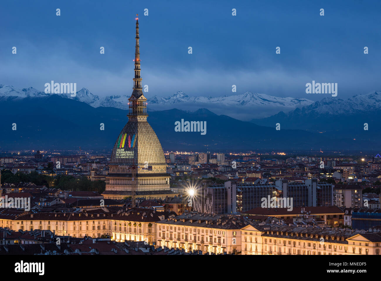 Torino, Italy - May 14, 2018: Turin skyline at dusk, panorama cityscape with the Mole Antonelliana showing 'International Book Fair 2018' sign. Scenic Stock Photo