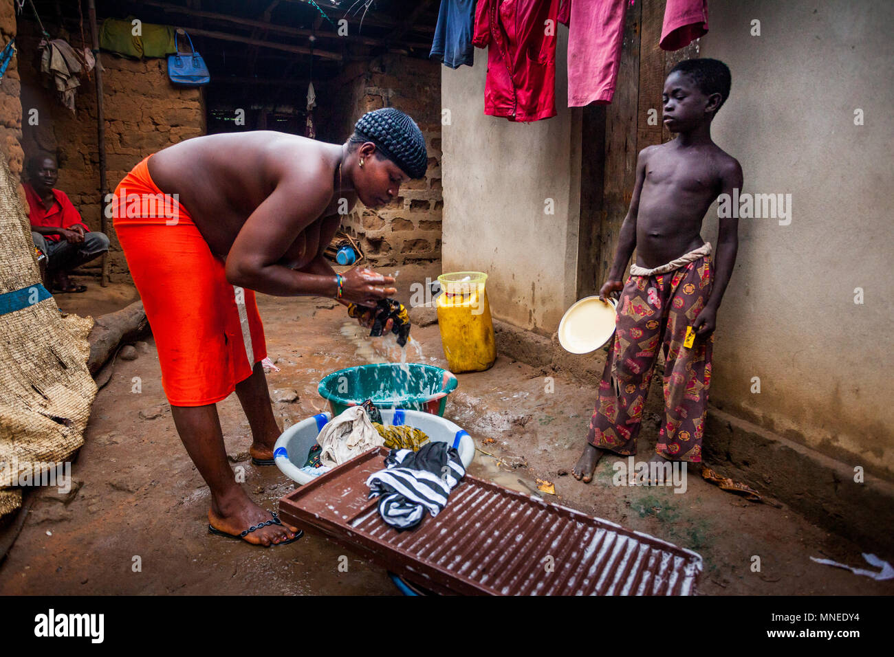 Yongoro, Sierra Leone - June 02, 2013: West Africa, unknown woman and boy wash clothes in the village in front of the capital of the Sierra Leone, Fre Stock Photo