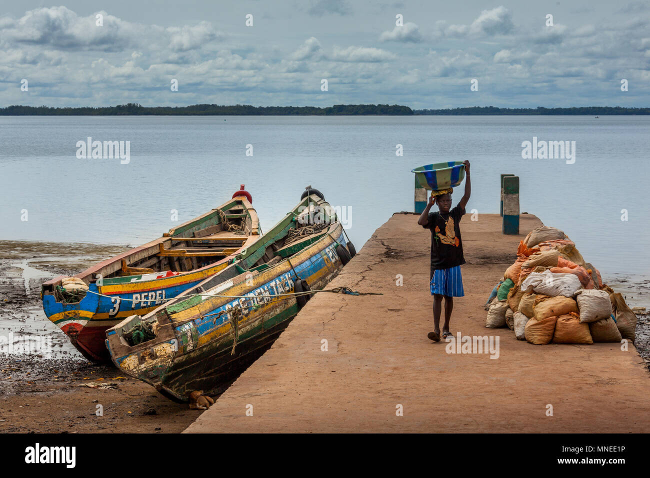 Bunce Island, Sierra Leone - June 02, 2013: West Africa, unknown fisherman unloads the material from the dock, Bunce Island was a British slave tradin Stock Photo