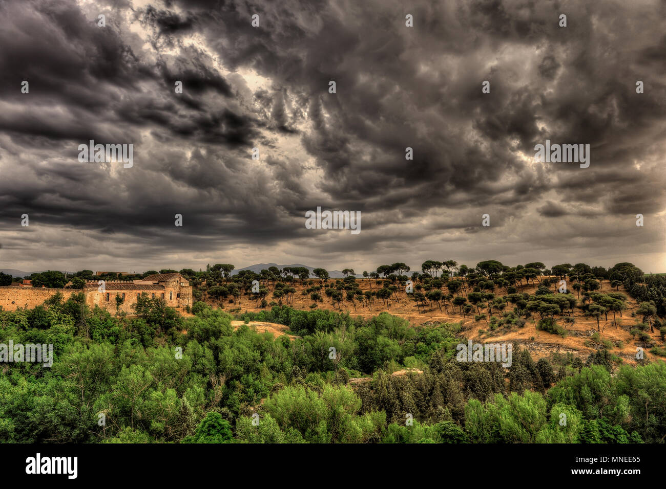 Spectacular view on the hill and greenery with dark, dramatic, stormy clouds in Segovia, Spain. Stock Photo
