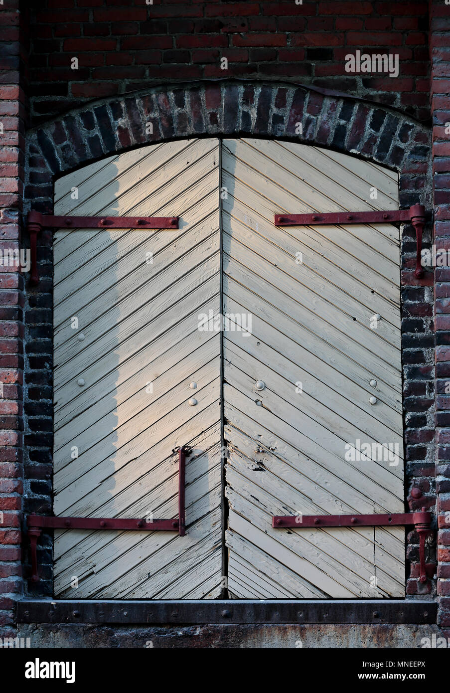 Closed and unlocked, old door on brickwall Stock Photo