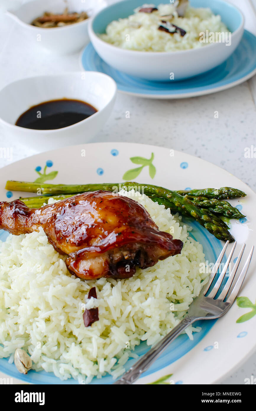 Teriyaki chicken drumsticks served with white rice on white table Stock Photo