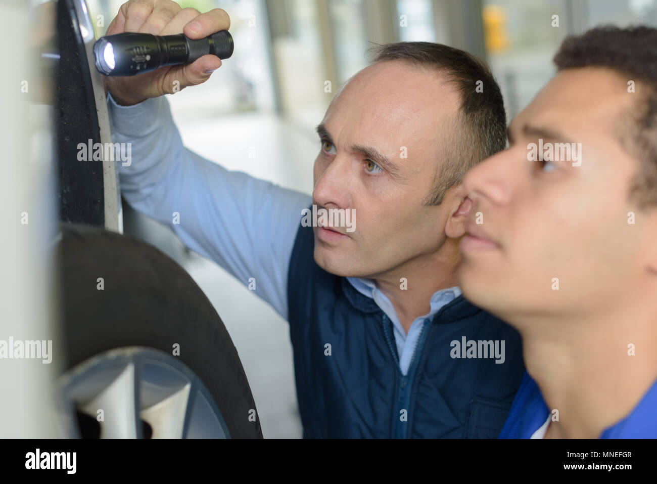 mechanic and apprentice working on car together Stock Photo - Alamy