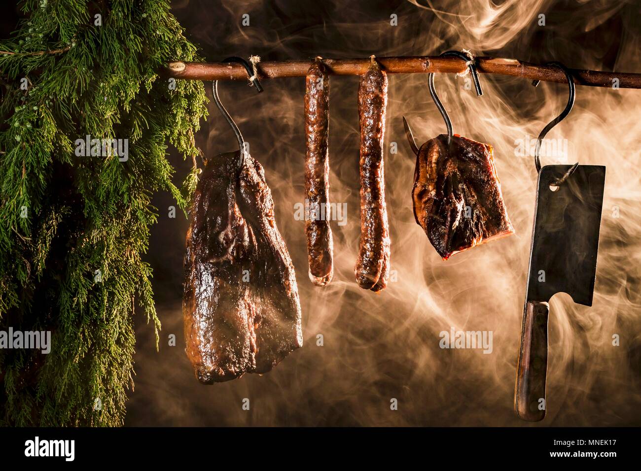 Ham, bacon and sausages in a smoking chamber Stock Photo