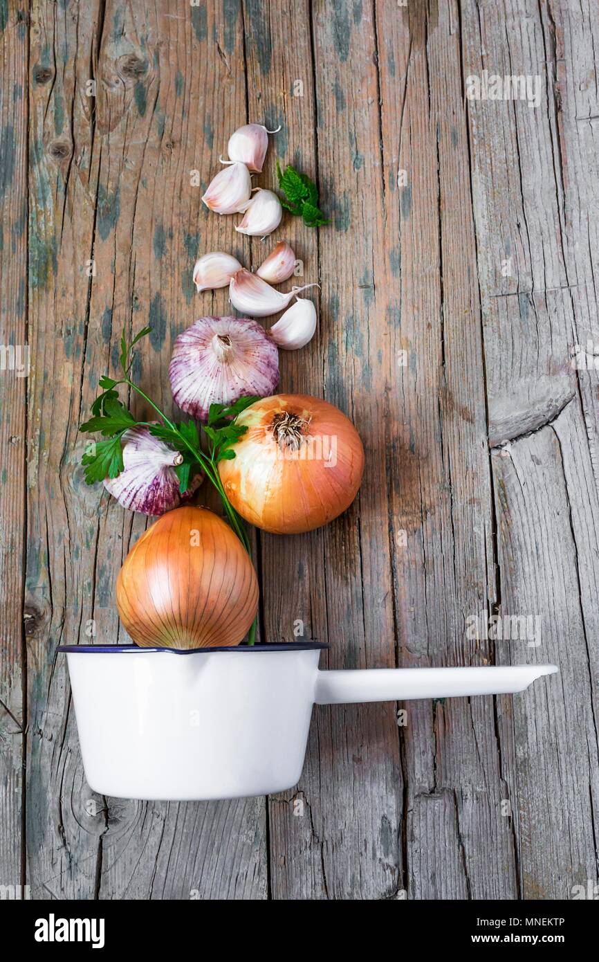 Garlic and onions with a saucepan on a wooden table Stock Photo