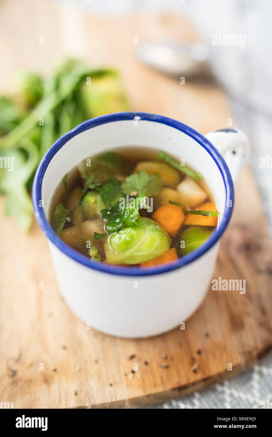 Vegetable broth in an enamel cup Stock Photo