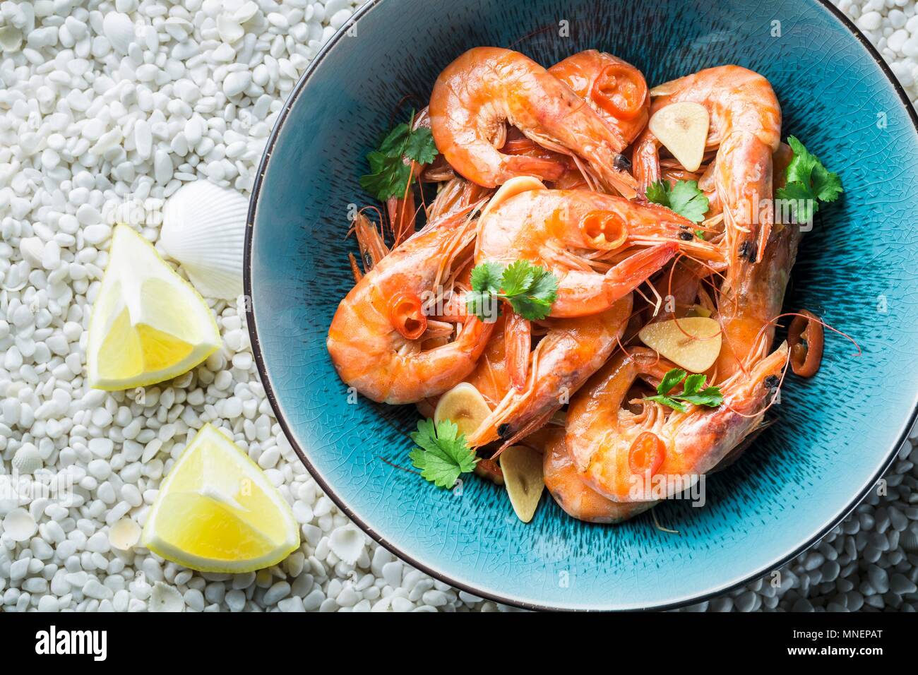 Prawns with garlic, parsley, chilli peppers and lemons Stock Photo