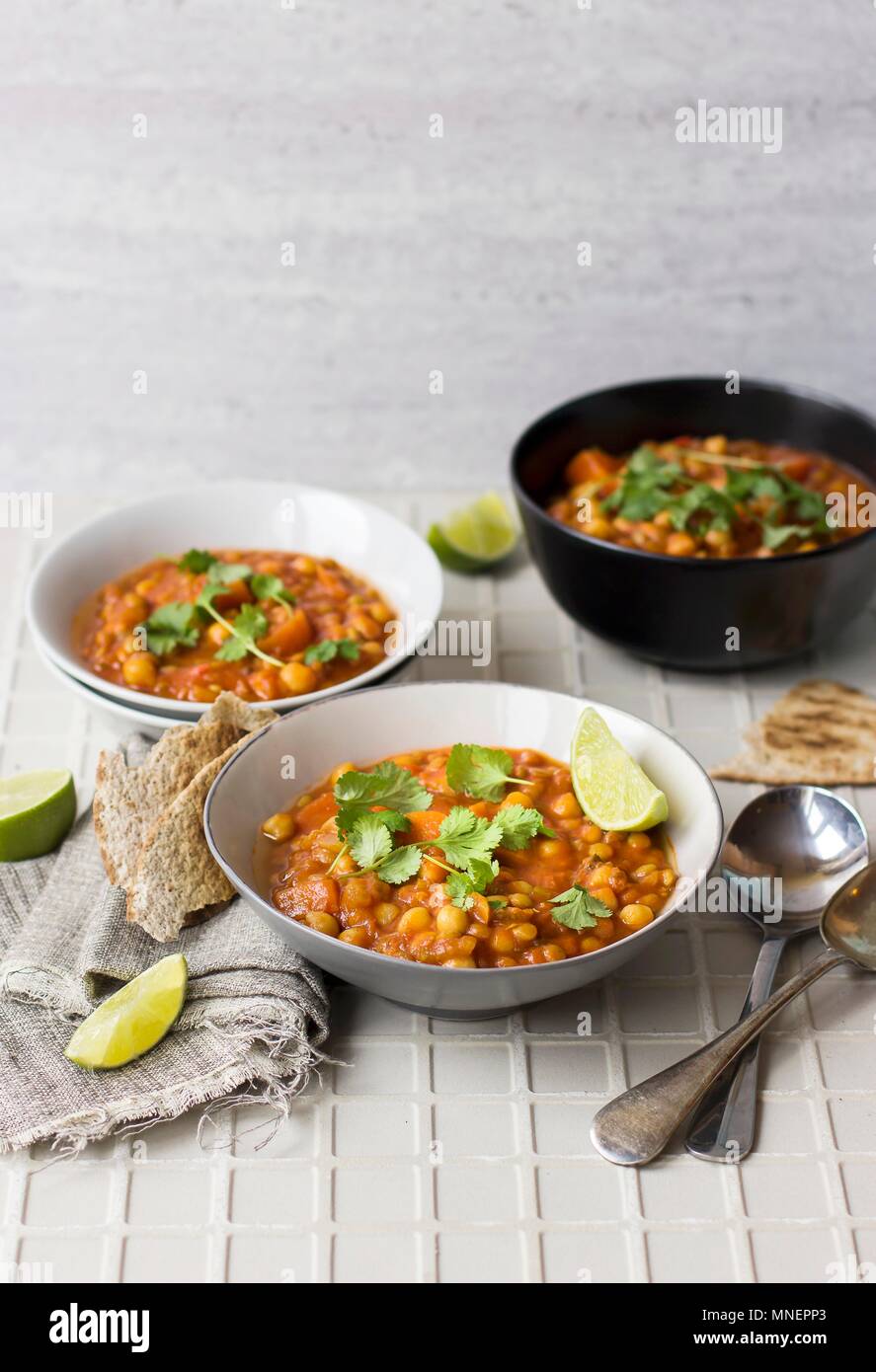 Harira soup with lime wedges and coriander Stock Photo